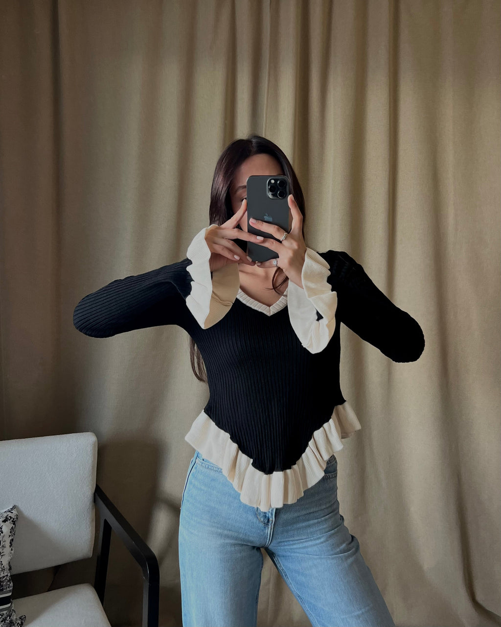 V-neck white sweater with ruffle detail in black.