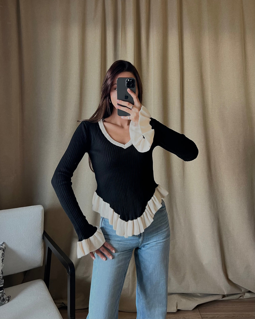 V-neck white sweater with ruffle detail in black.